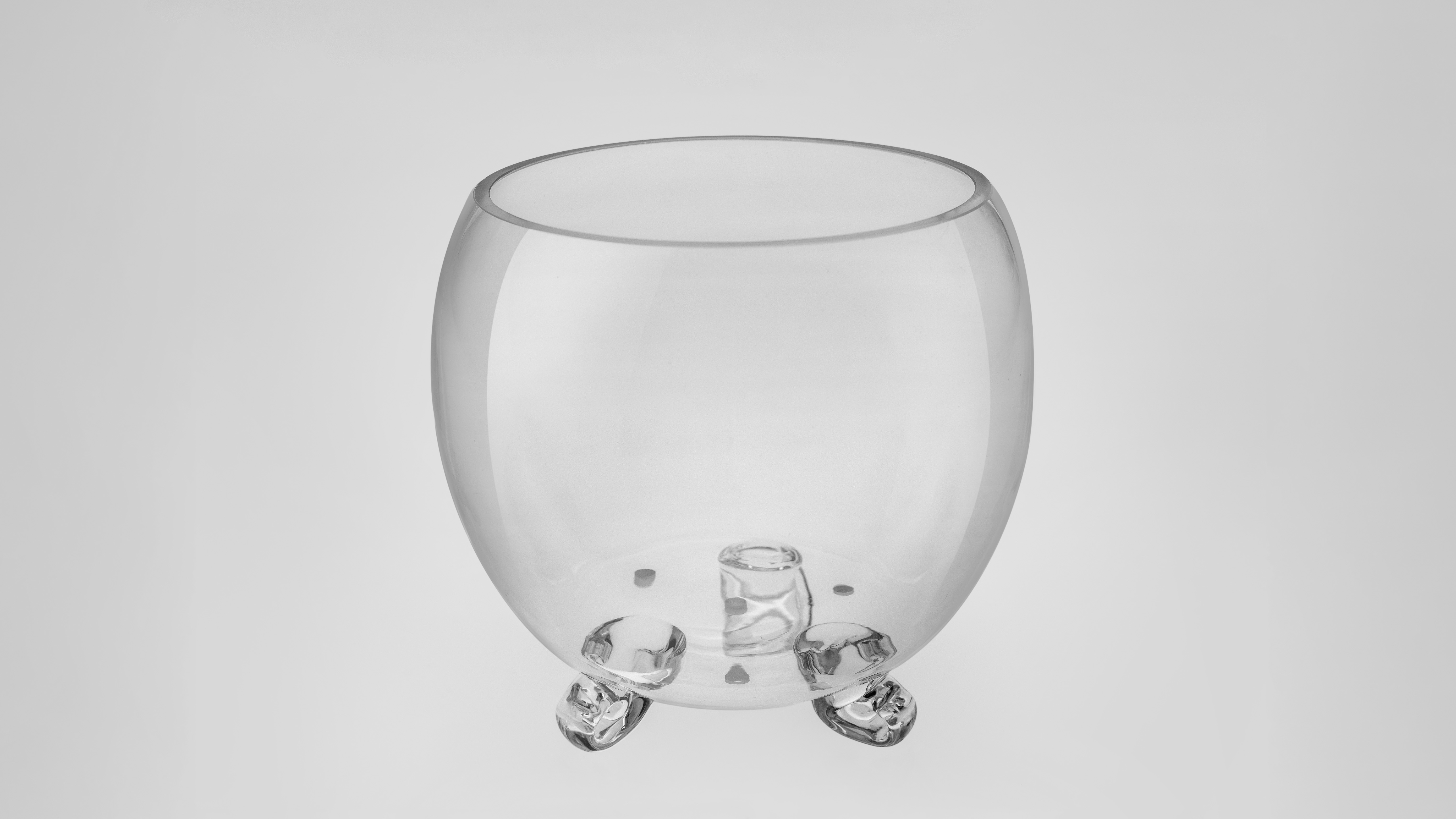 Glass vessel with orchids in a garden setting
